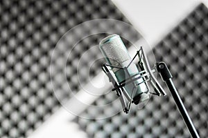 Microphone in a professional recording or radio studio, sound insulation in the blurry background