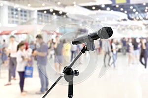 Microphone public relations on Blurred many People within Department store Shopping Mall Event hall inside background