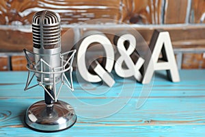 Microphone with Q & A letters in the background, a set for podcast interviews