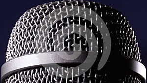 The Microphone Rotates on a Black Background. Dynamic Microphone Grid Spins Close-up