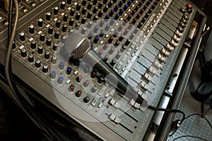 Microphone on sound mixer background.