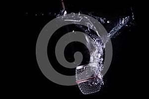 Microphone Splashing into Water on Black Background