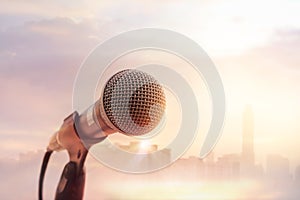 Microphone on stage in concert on sunset city background