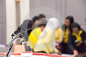Microphone on stage with conference hall blurred background.