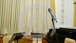 Microphone on stage with music stand. Media. Small scene in music conservatory.