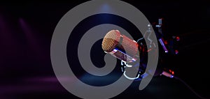 Microphone on stage in neon lights. live performance, karaoke and music concert background. copy space