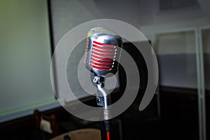 Microphone is on stage in a nightclub. Singer holds and sings into the microphone. Bright light of the club Shine on the MIC.