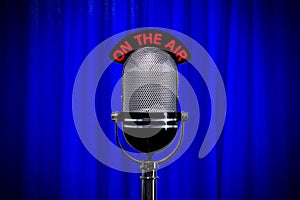 Microphone on stage with spotlight on blue curtain