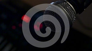 Microphone on a stand located in a music studio recording booth under low key light