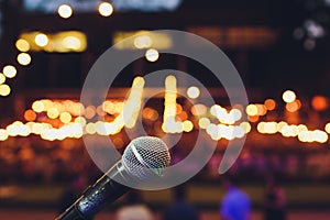 microphone on a stand up comedy stage with colorful bokeh , high contrast image.