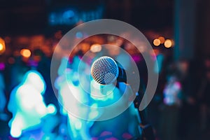 microphone on a stand up comedy stage with colorful bokeh , high contrast image.