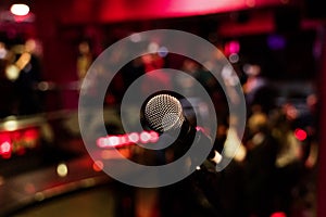 Microphone on a stand up comedy stage with colorful bokeh , high contrast image