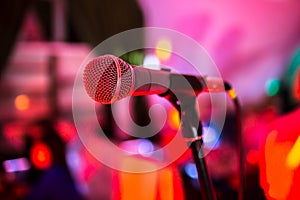 Microphone stands on stage in a nightclub. Bright club light shines on MIC. Performances in the night club