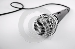 Microphone with a wire on white background. Silver mic