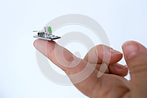 Microprocessor on finger of female hand on white background, research, development of microelectronics and processors, concept