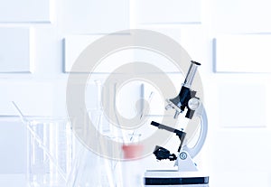 Microscope and glass apparatuses in laboratory for use to analyse in microbiology and chemical