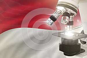 Microscope on Indonesia flag background - science development concept. Research in pharmaceutical industry or physics 3D