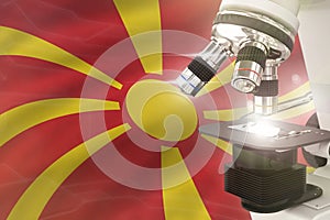 Microscope on Macedonia flag background - science development concept. Research in genetics or microbiology 3D illustration of
