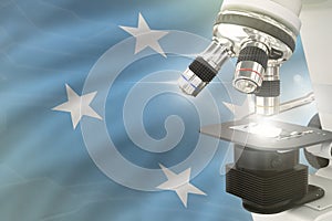 Microscope on Micronesia flag background - science development concept. Research in clinical medicine or biotechnology 3D