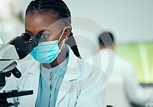 Microscope, science and female scientist with a face mask in a medical pharmaceutical lab. Professional, scientific and