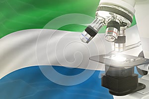 Microscope on Sierra Leone flag background - science development concept. Research in pharmaceutical industry or healthcare 3D