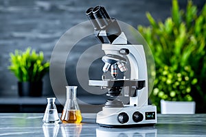A microscope sitting on top of a table next to a beaker of liquid
