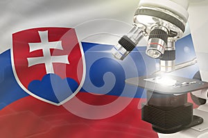 Microscope on Slovakia flag background - science development concept. Research in chemistry or healthcare 3D illustration of