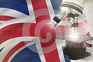 Microscope on United Kingdom (UK) flag background - science development concept