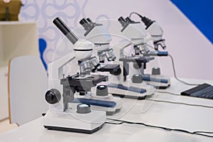 Microscopes on white table at science exhibition - laboratory equipment