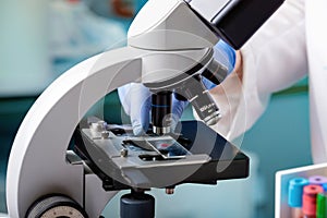 Microscopist scientist examining biological samples with a microscope in the laboratory