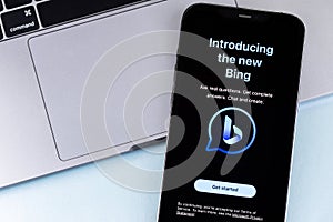 Microsoft Bing logo mobile app on the screen smartphone iPhone with Macbook. Microsoft Bing is a search engine developed by the