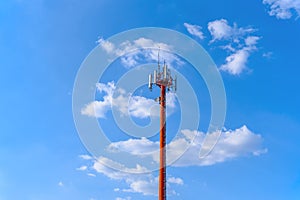 Microwave and cellular tower with partly cloudy blue sky