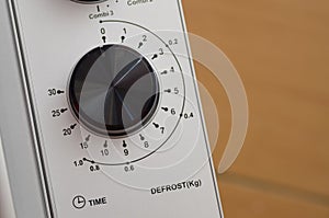 Microwave control panel detail featuring time and kilogram defrost selector dial