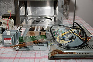 Microwave oven disassembled on a kitchen table