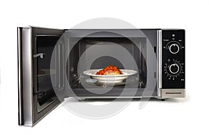 The microwave oven is warm chicken spaghetti.