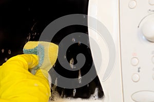 Microwave oven washing using a detergent solution with foam