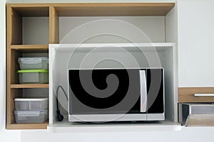 Microwave on wooden shelf