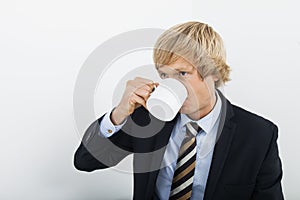 Mid adult businessman drinking coffee over white background