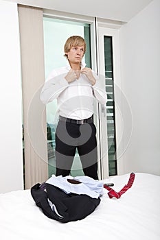 Mid adult businessman getting ready in bedroom