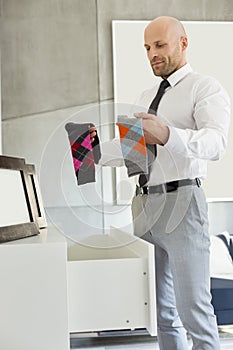 Mid adult businessman selecting socks at home