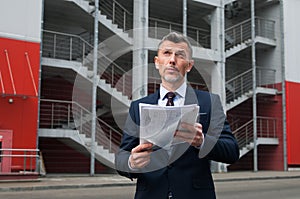 Mid adult businessman writing on clipboard in metal industry photo