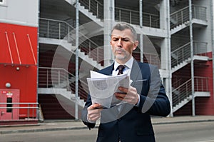 Mid adult businessman writing on clipboard in metal industry photo