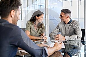 Mid adult couple consulting bank agent for their savings