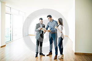 Couple Signing Sale Purchase Agreement By Broker In New Home photo