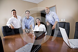 Mid-adult Hispanic office workers in boardroom