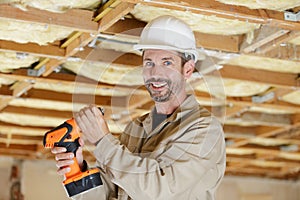 Mid-adult man drilling hole in wall