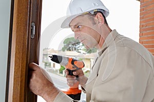 Mid-adult man drilling hole in wall