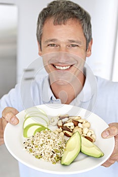 Střední dospělý muž držení deska z zdravý jídlo 