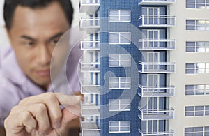 Mid adult man inspecting architectural model close-up