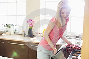 Mid adult woman baking cookies in kitchen